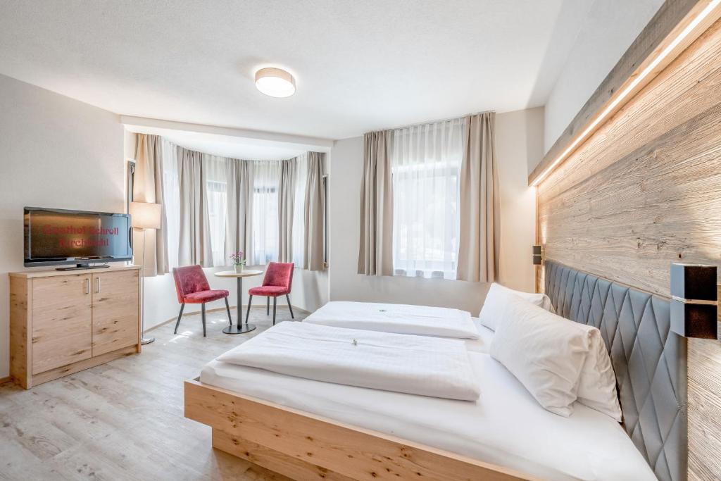 基希比希尔Gasthof Schroll的酒店客房设有一张大床和一台电视。