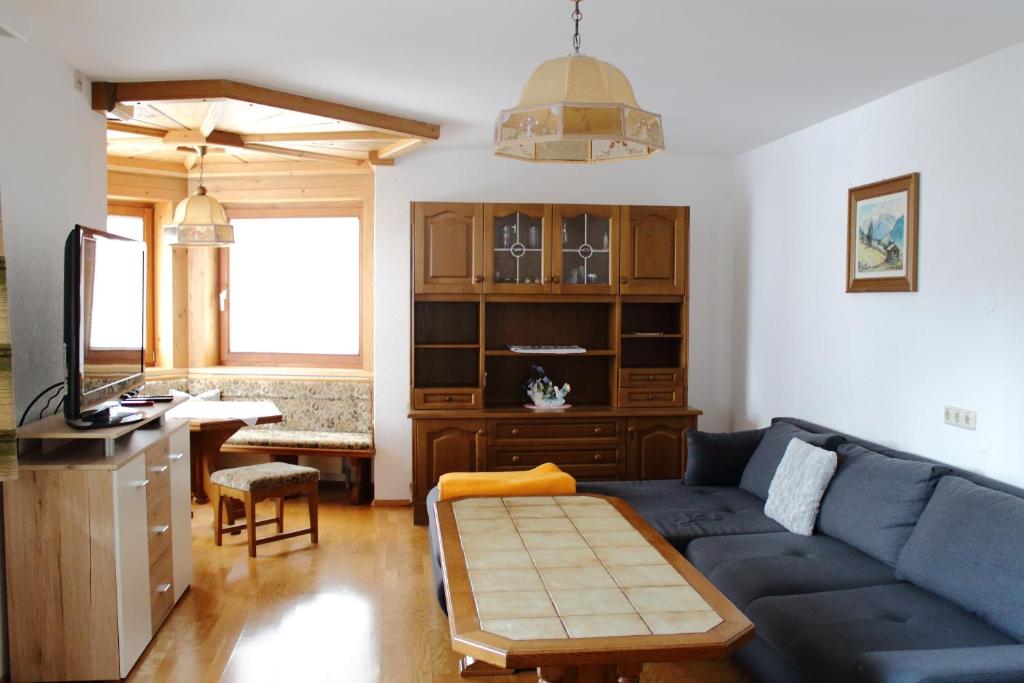 平茨高谷地霍勒尔斯巴赫Ferienwohnung Innerhofer的客厅配有蓝色的沙发和书桌