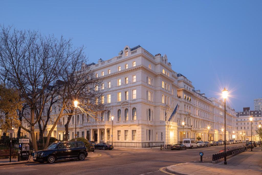 伦敦Hapimag Apartments London的夜行的街道上一座白色的大建筑