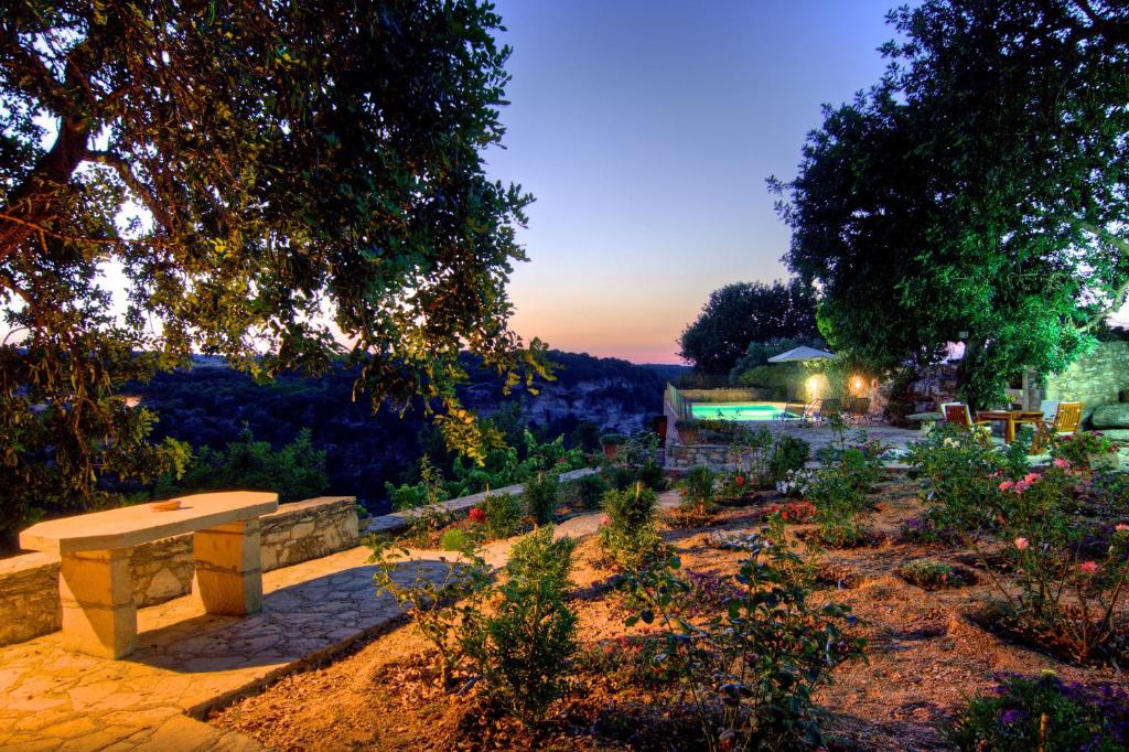 ElefternaVilla Nikolaos的黄昏时花园的公园长凳