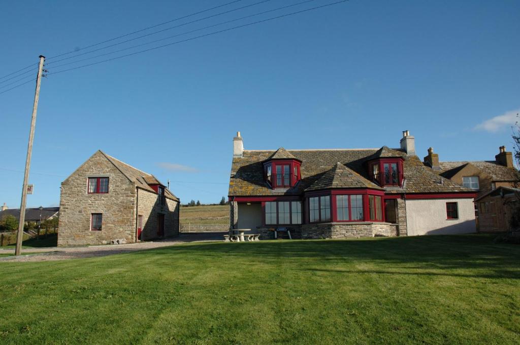 LatheronCraiglea Lodge & Barn的绿色庭院中带红色窗户的大房子