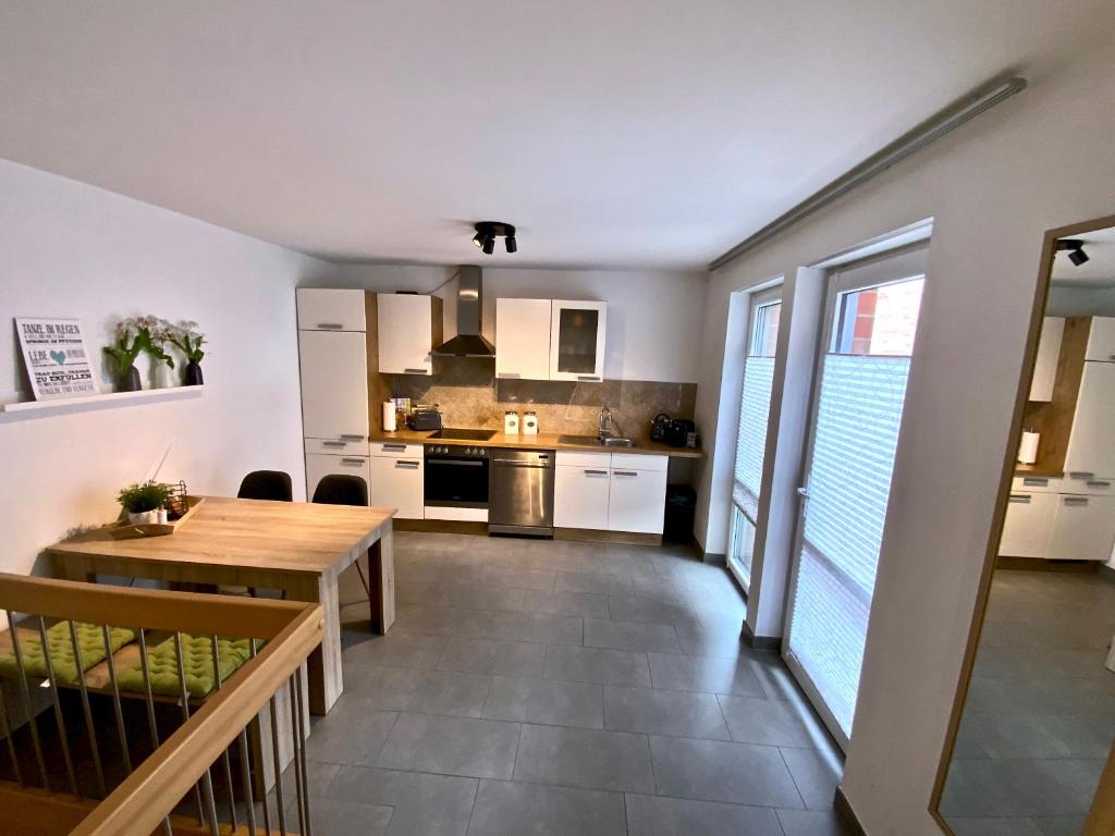 布吕根4*+ Maisonette-Apartment的厨房以及带木桌的用餐室。