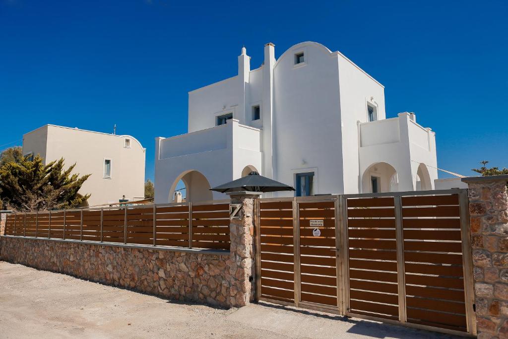 莫诺利索斯The Z Private Villa, Santorini的白色建筑前的木栅栏