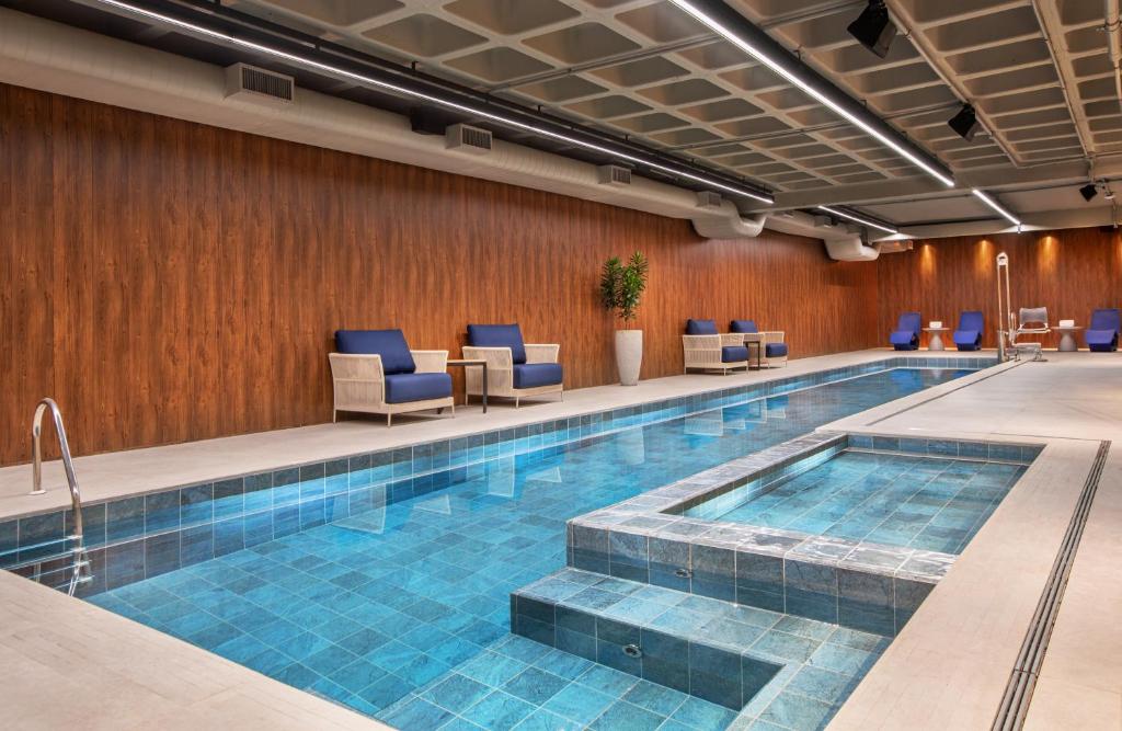圣保罗保利斯塔美利亚酒店的一个带蓝色椅子的酒店客房的游泳池