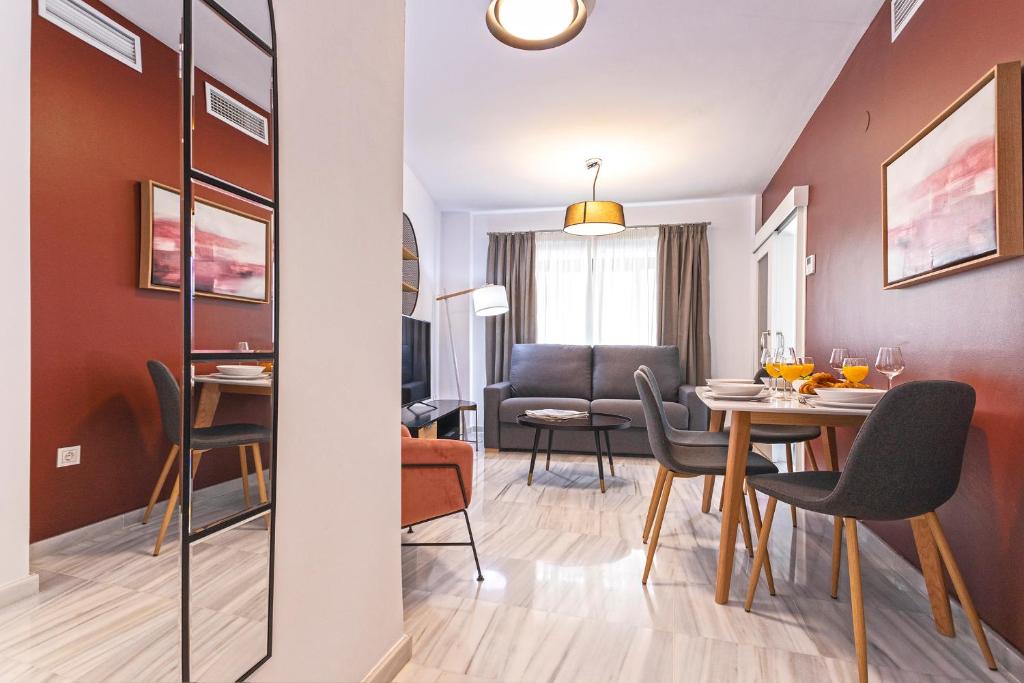 马拉加Málaga Rivas 34 Suites Homes的用餐室以及带桌椅的起居室。