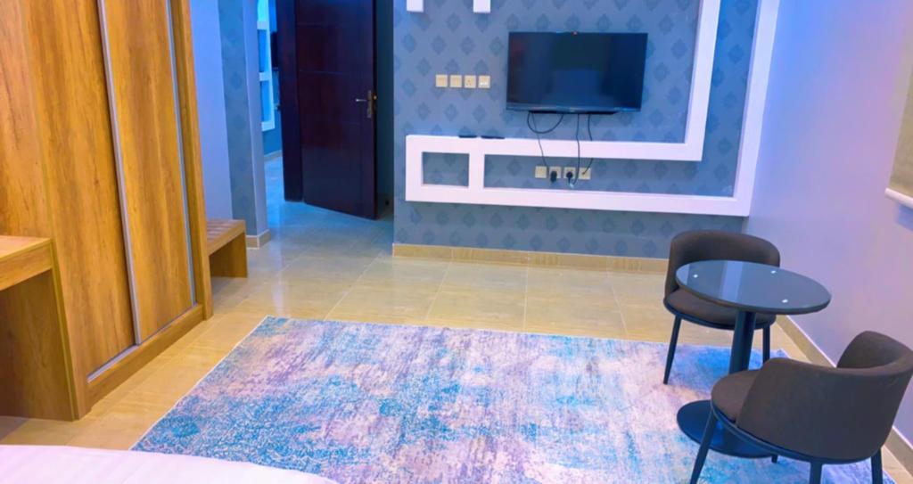 欧拉شقق Flower-z的一间设有两把椅子、一台电视和地毯的房间