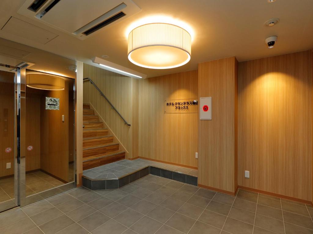 带广Hotel Grand Terrace Obihiro Annex的走廊上设有楼梯和灯
