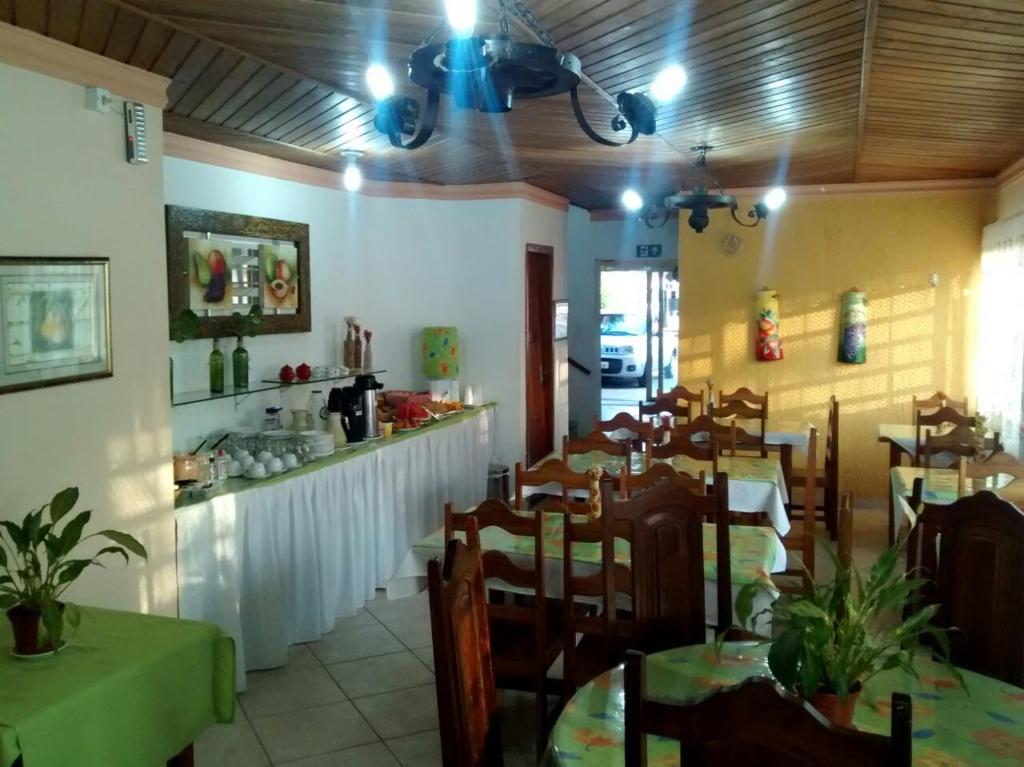 瓦尔任博尼塔Aconchego Canastra Hotel的餐厅内带桌椅的用餐室