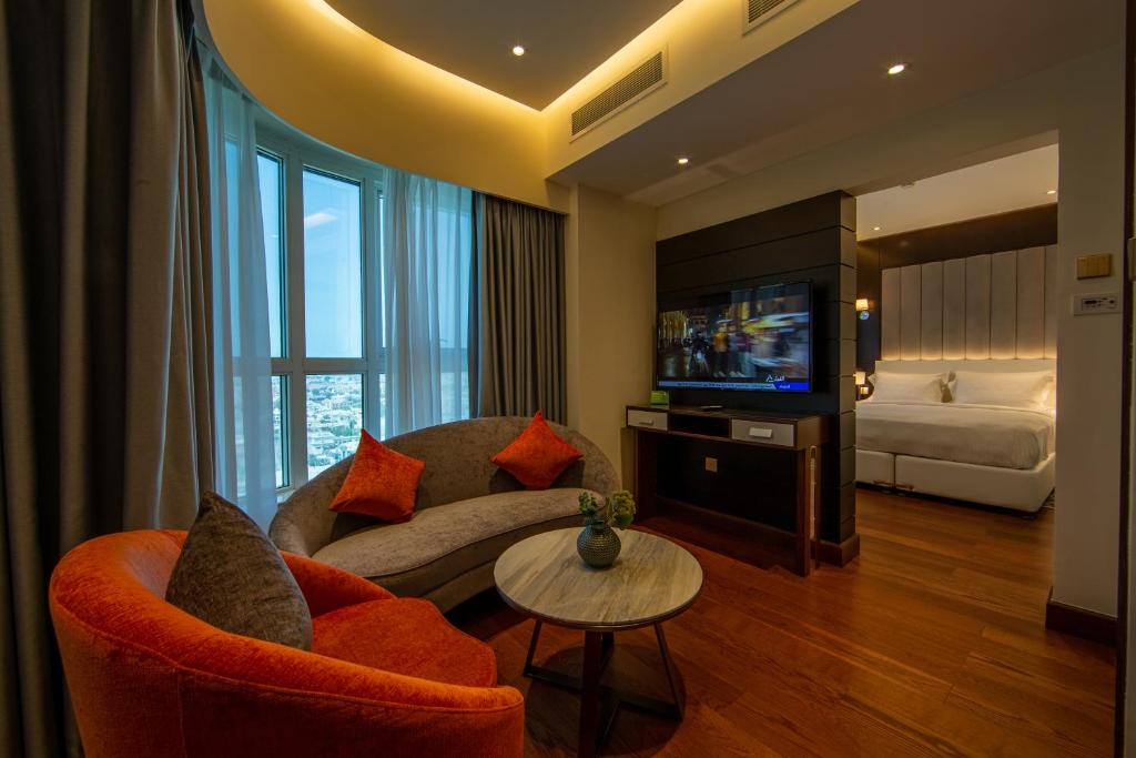 迪拜第一城堡套房酒店的带沙发、电视和床的客厅