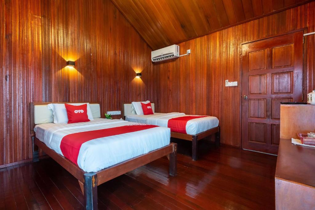 仙本那Bubul Village Stay Semporna的一间卧室设有两张床和木镶板墙