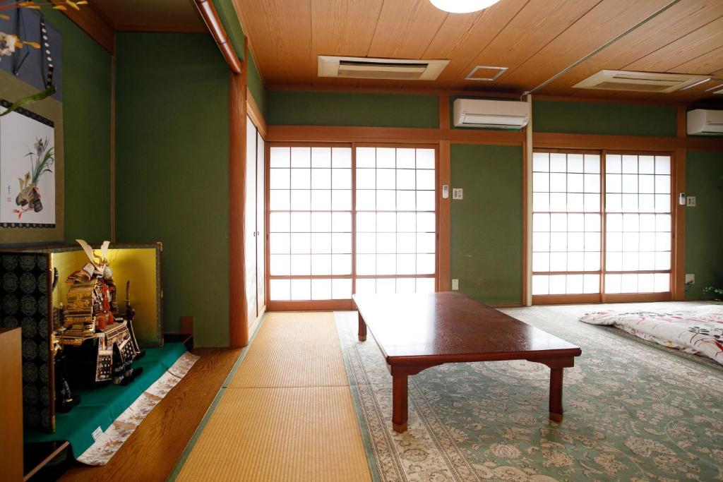 东大阪市Gairoju / Vacation STAY 3715的绿墙客房内的一张桌子