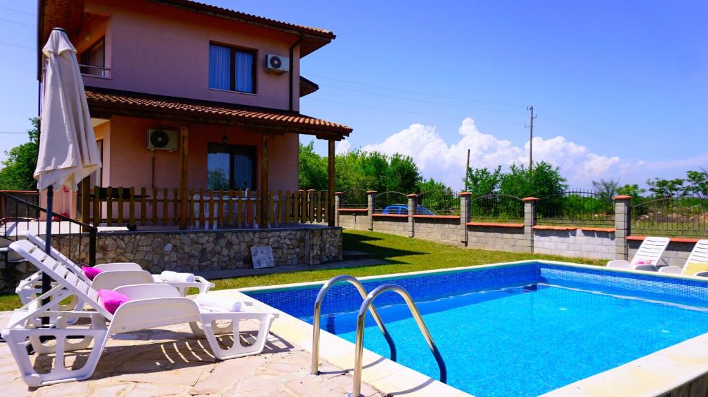 布尔加沃Вила Марна - Villa Marna的一个带椅子的游泳池以及一座房子