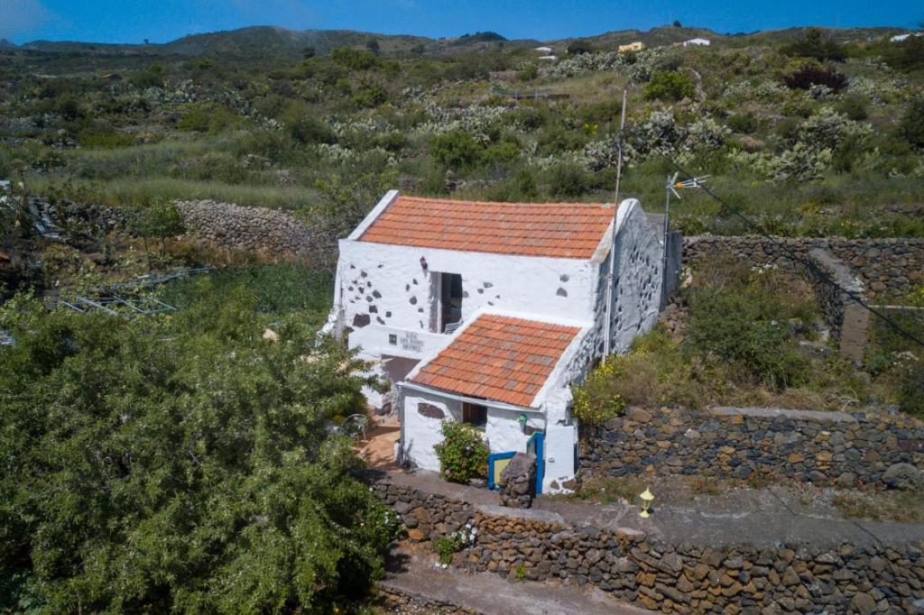 Isora帕索斯格兰达斯乡村公寓的山丘上一座白色的小房子,有红色屋顶