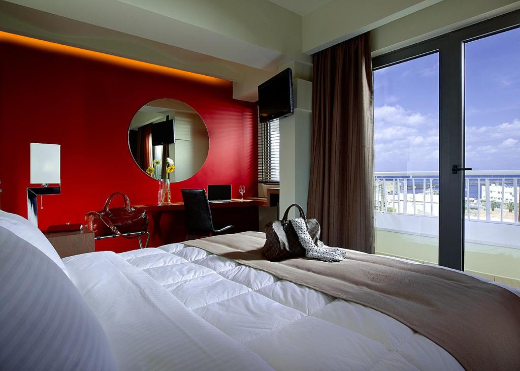海若克利欧Lato Annex Boutique Rooms的配有一张大床和镜子的酒店客房