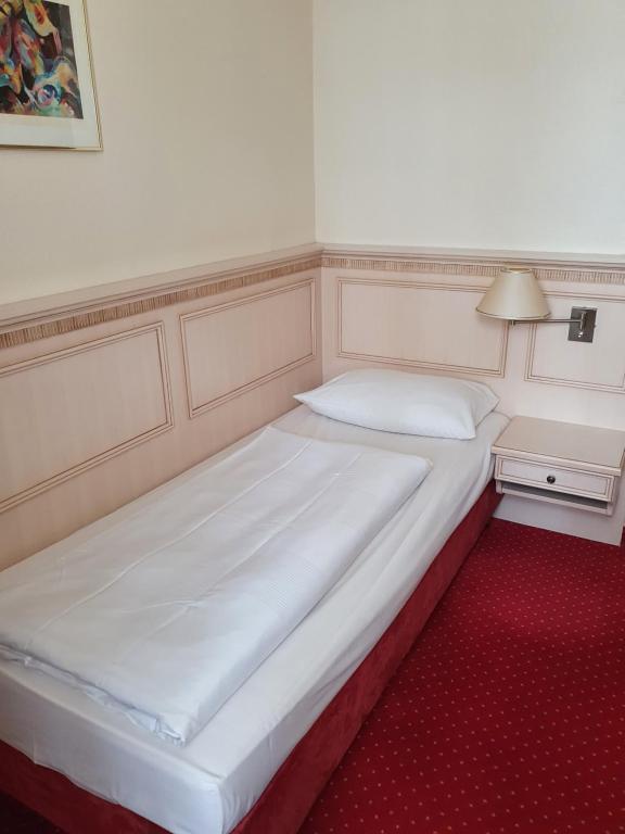 坎普-林特福特赌场公园酒店的一张大白色的床,位于一间铺有红地毯的房间里