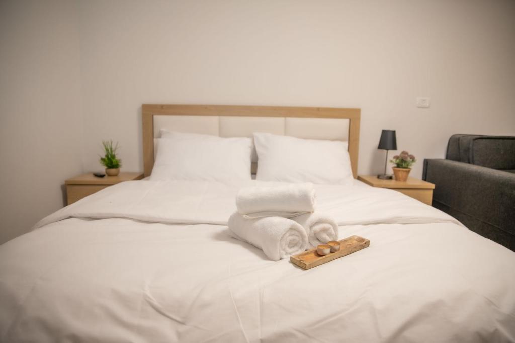 迈季代勒舍姆斯Adan - Suietes的一张带毛巾的床和一张木制毛巾托盘