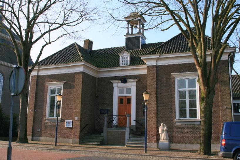 Hooge ZwaluweBoetiekhotel Ons Oude Raadhuis digitaal inchecken的前面有雕像的砖砌建筑