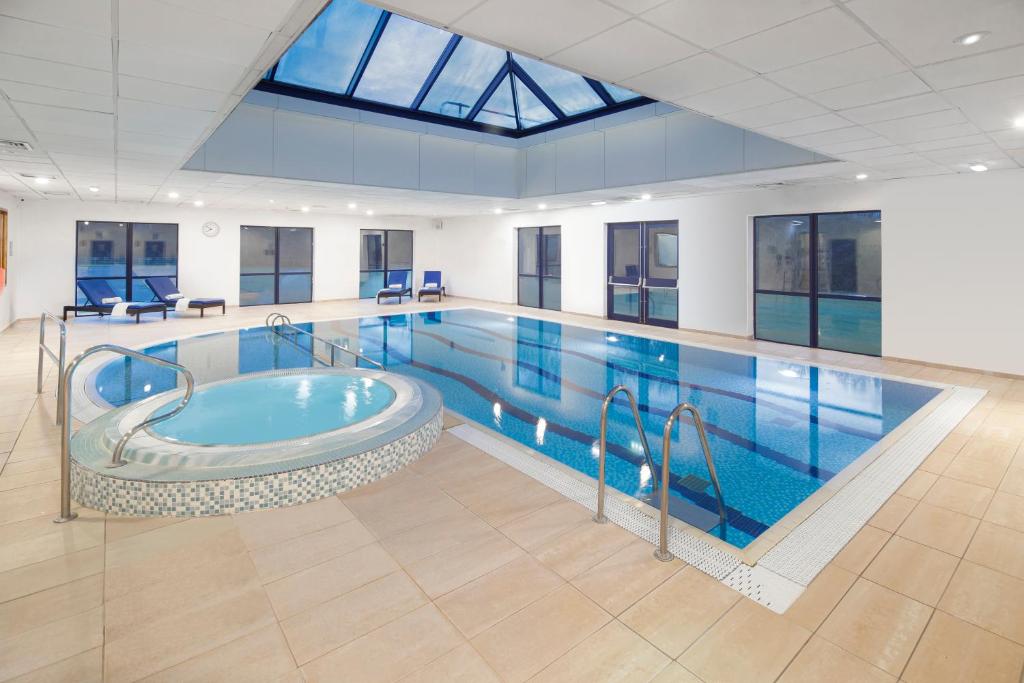 彼得伯勒假日彼得伯勒西区酒店的大楼内带热水浴池的大型游泳池