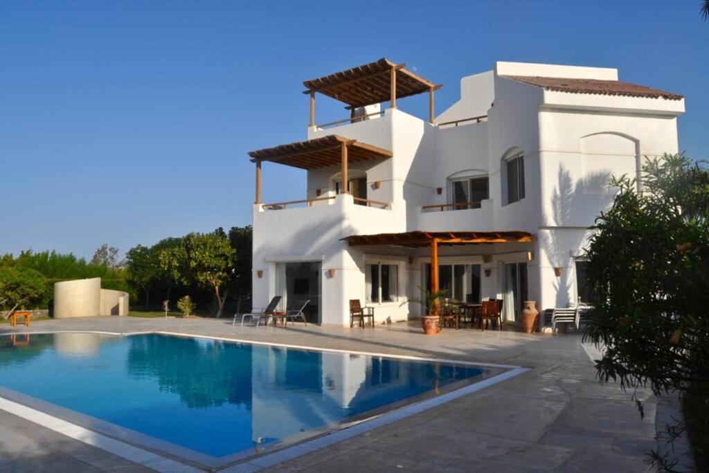 赫尔格达Villa with 5 bedrooms & 4 bathrooms - private heated pool的一座白色的房子,前面设有一个游泳池