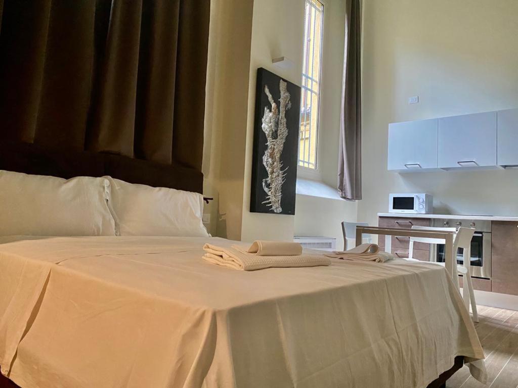 博洛尼亚Savenella Apartments的一张白色的床,上面有两条毛巾