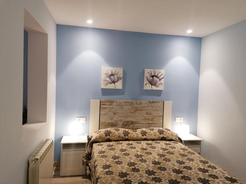 莫利纳德亚拉贡Apartamentos El Cid的卧室配有一张墙上三幅画作的床