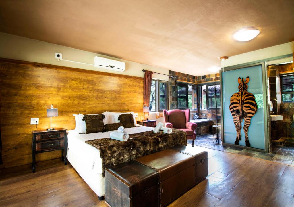 玛洛斯帕克Adventure Bush Villa的卧室配有一张床,墙上挂有斑马画