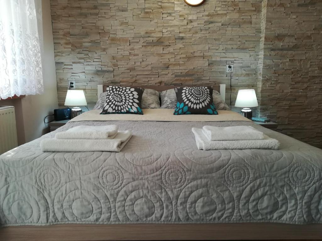 维尔卡瑟Cichy Zakątek的卧室内的一张大床,卧室设有砖墙