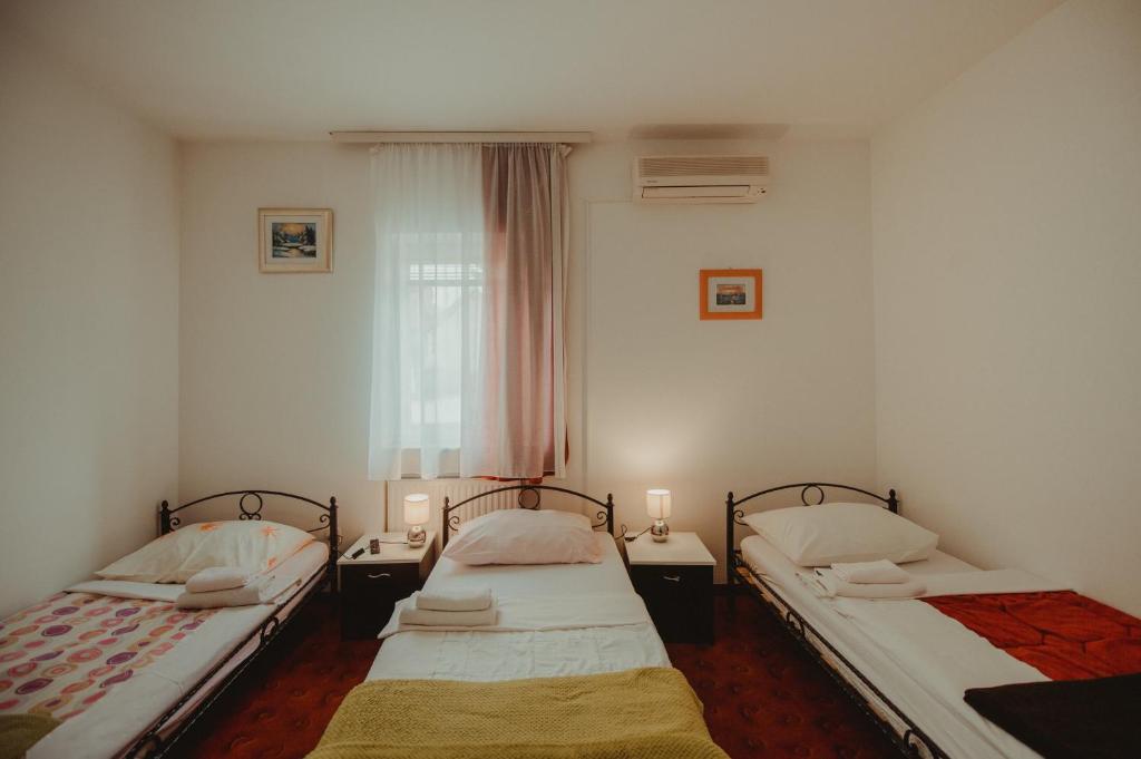 贾科沃B&B Laguna的配有两盏灯的小房间内的两张床