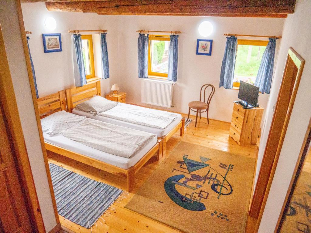 Kunratice盆梓永U森普旅馆的一间小卧室,配有两张床和椅子