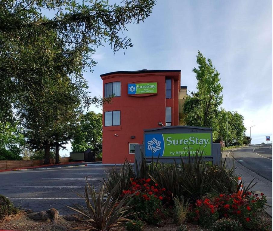 瓦列霍SureStay Hotel by Best Western Vallejo Napa Valley的前面有标志的红色建筑