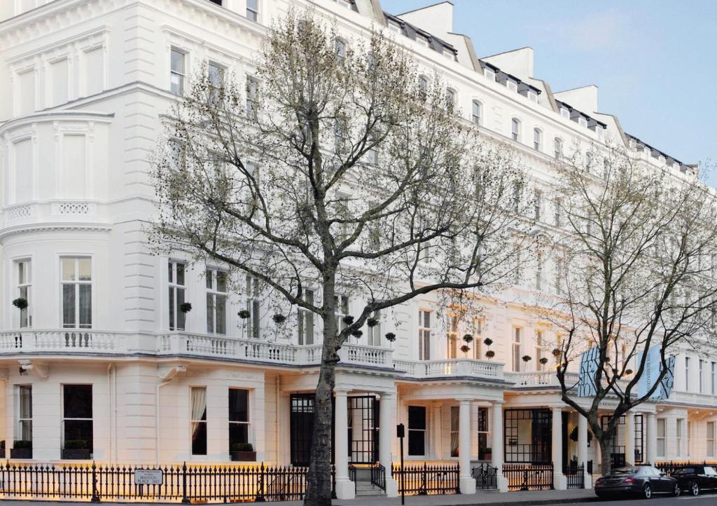 伦敦肯辛顿酒店的前面有棵树的白色建筑
