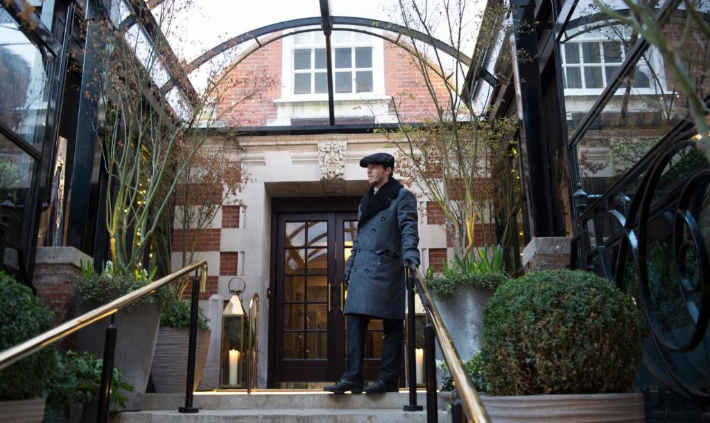 伦敦布卢姆茨伯里酒店的站在建筑物台阶上的男人