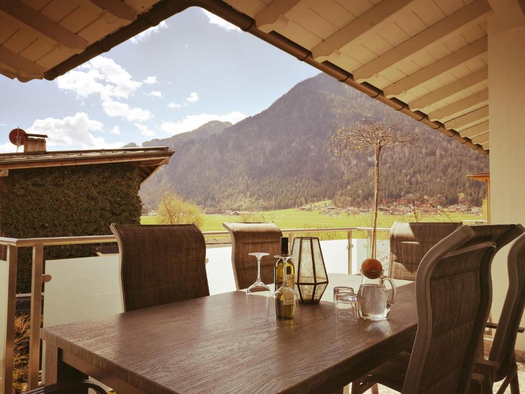 齐勒谷地施特拉斯Ferienwohnungen Strass im Zillertal的一张带椅子的木桌,享有山景