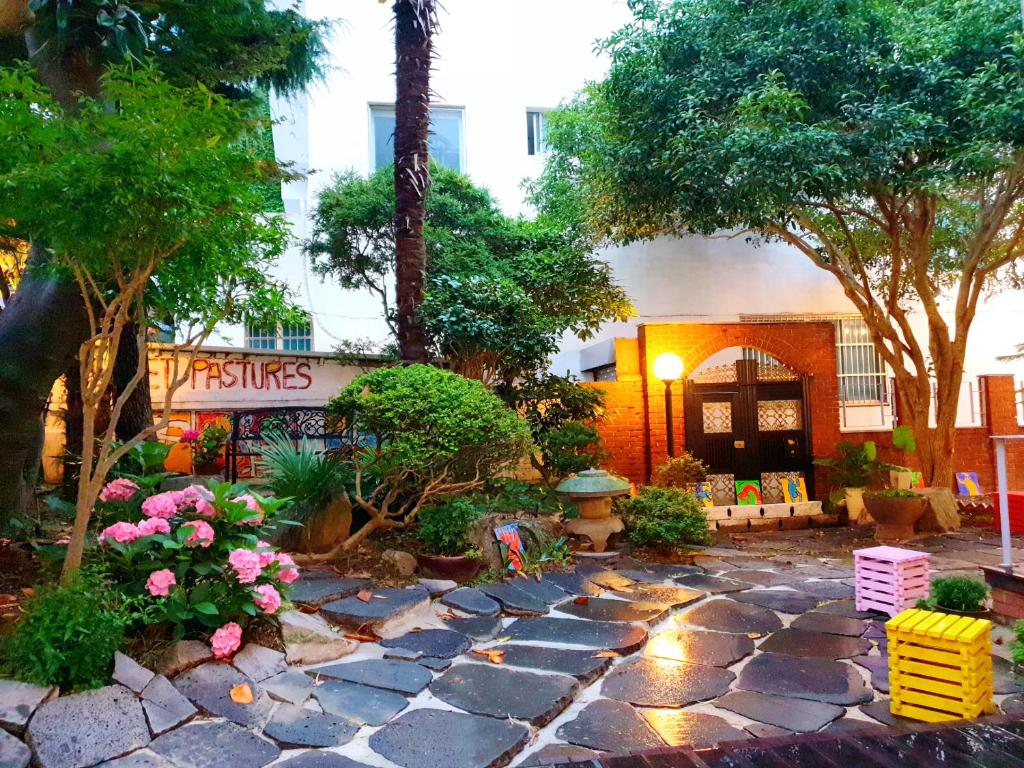 木浦市Gallery Family Hotel的一座花园,在一座建筑前设有石头人行道
