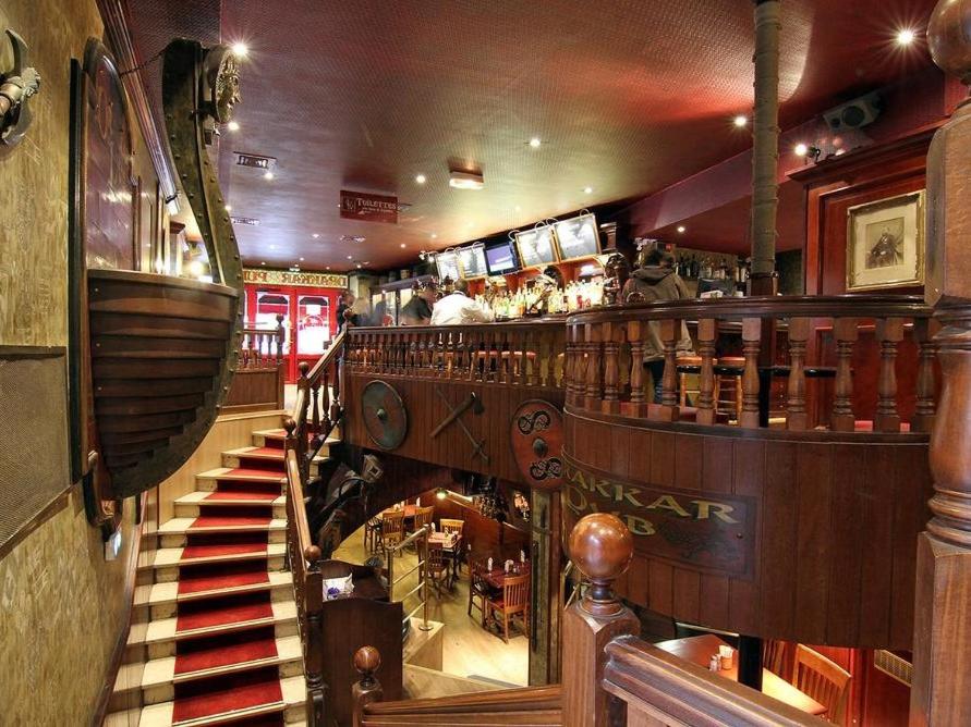 芒德Logis Hôtel Restaurant Le Drakkar的享有带楼梯的餐厅和一间酒吧的景致