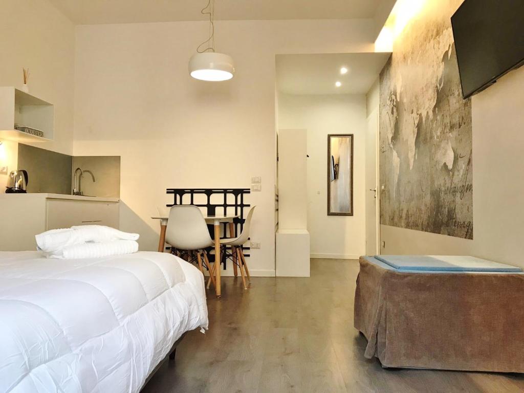 马泰拉Angolo di Ninno的一间卧室配有一张床铺和一张桌子,还设有一间厨房