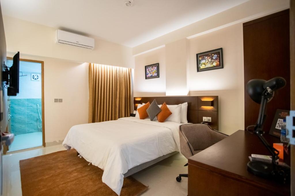 巴纳内拉斯Jatra Flagship Sylhet City Centre的一间卧室配有一张床、一张桌子和一台摄像机