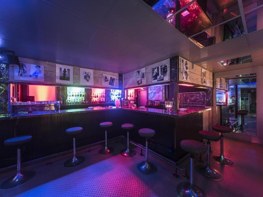 Belval乌西内酒店的紫色灯光的房间,有凳子的酒吧