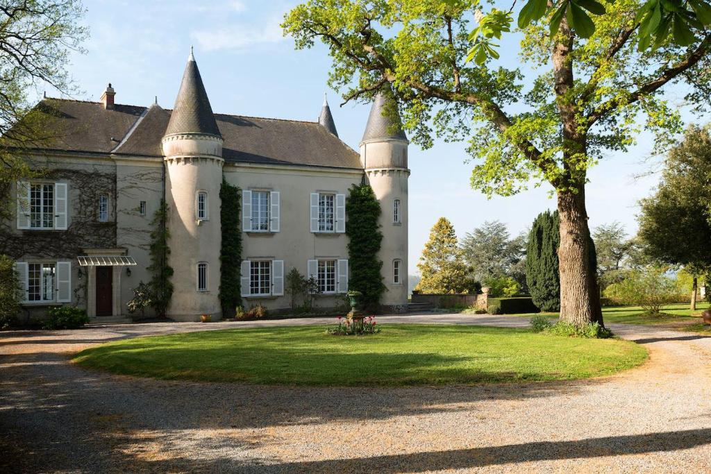 OudonChâteau Haute Roche的一座古老的城堡,前面有棵树