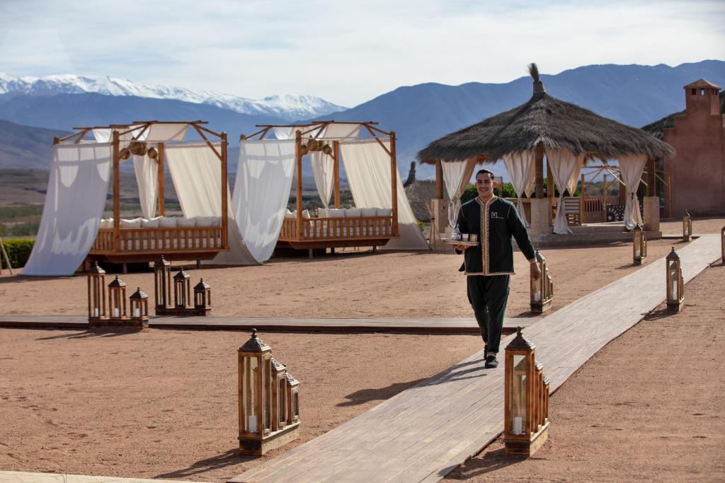 拉拉塔可库斯特Kalyptus Luxury Camp的人走下人行道,有一排帐篷