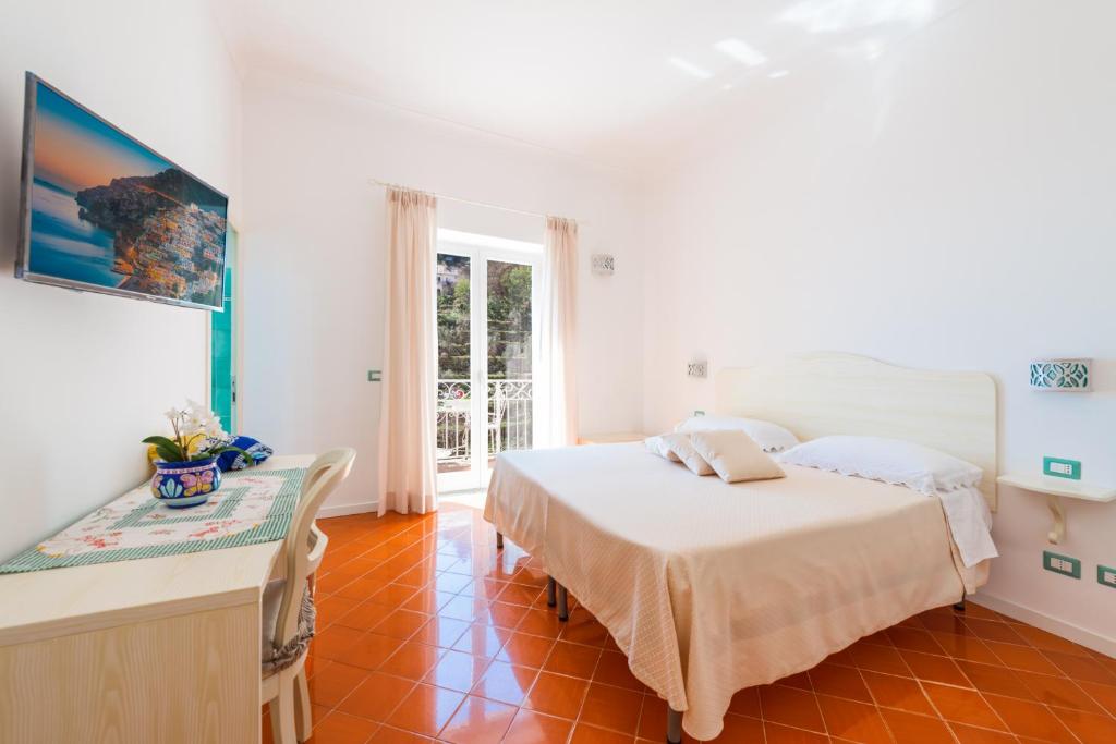 波西塔诺Casa Pietro的卧室配有一张床和一张桌子