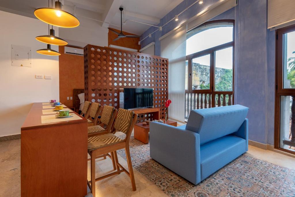 卡塔赫纳Ganem Suites Cartagena的客厅配有桌子和蓝椅