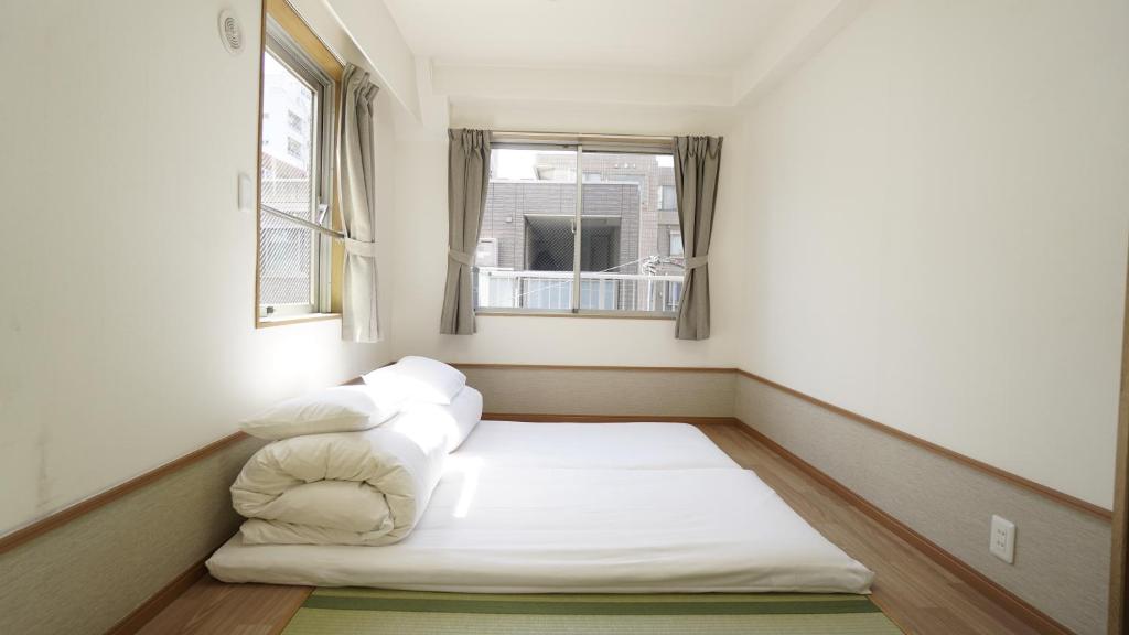 东京池袋宾馆的窗户客房内的小床