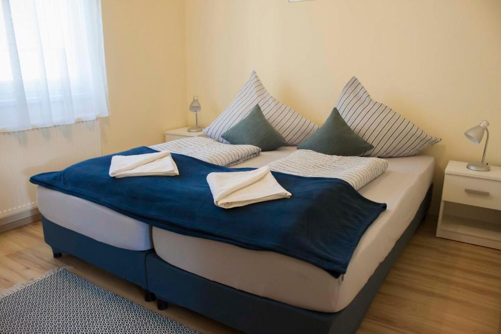 凯斯特海伊Azúr Apartman Keszthely的一间卧室配有一张大床,提供蓝色的床单和枕头