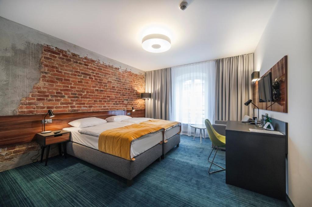 罗兹托巴克罗兹酒店的酒店客房,设有床铺和砖墙