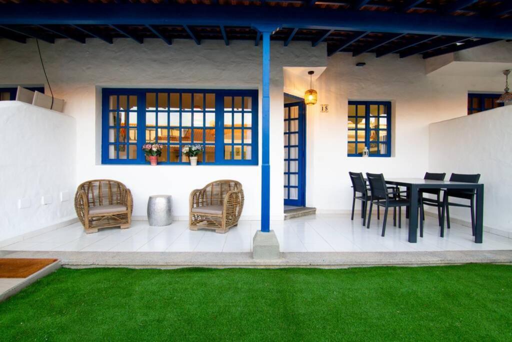帕斯托布兰克Recién renovado apartamento a 2 min de la playa的天井配有黑色桌椅和绿色草地。