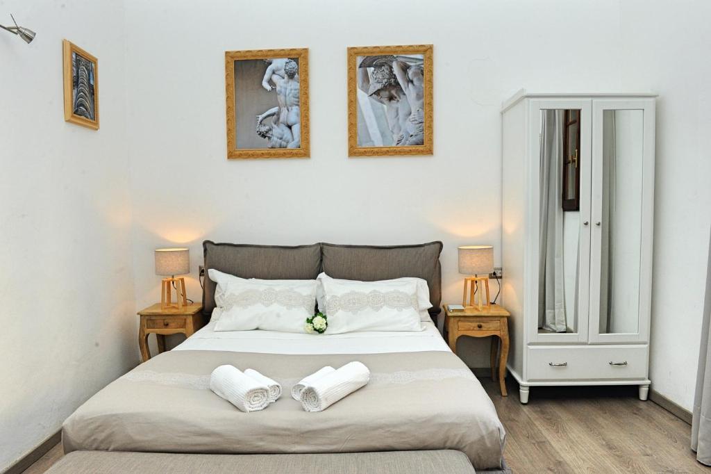 佛罗伦萨Domus Plaza的一间卧室配有一张床,上面有两条毛巾