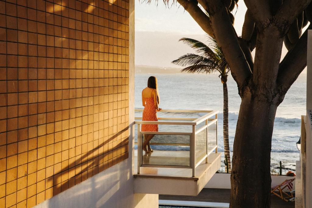 蓬塔德尔西达尔戈Punta Paradiso的站在一个眺望海洋的阳台上的女人
