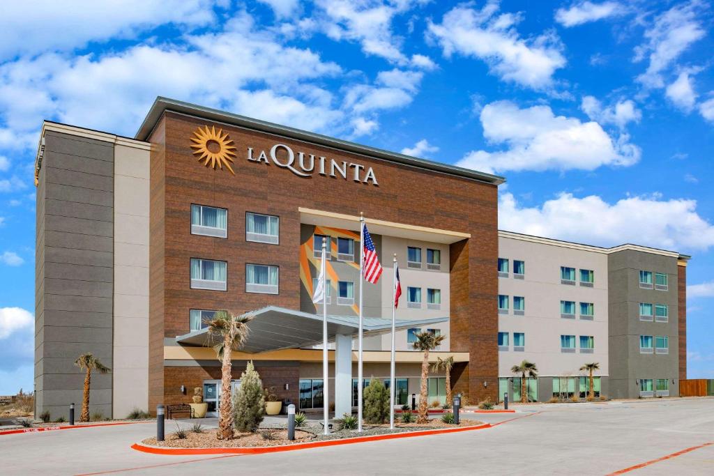 斯托克顿堡La Quinta Inn & Suites by Wyndham Fort Stockton Northeast的一座酒店大楼,上面有“五字”字样