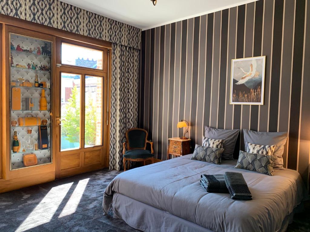亚眠Maison Longuevie的一间卧室配有一张带条纹墙的床